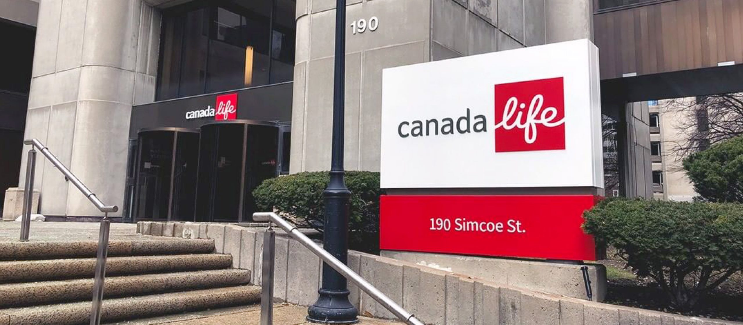 Custom fabricated Canada Life branded podium sign with red base, located outside 190 Simcoe St., Toronto