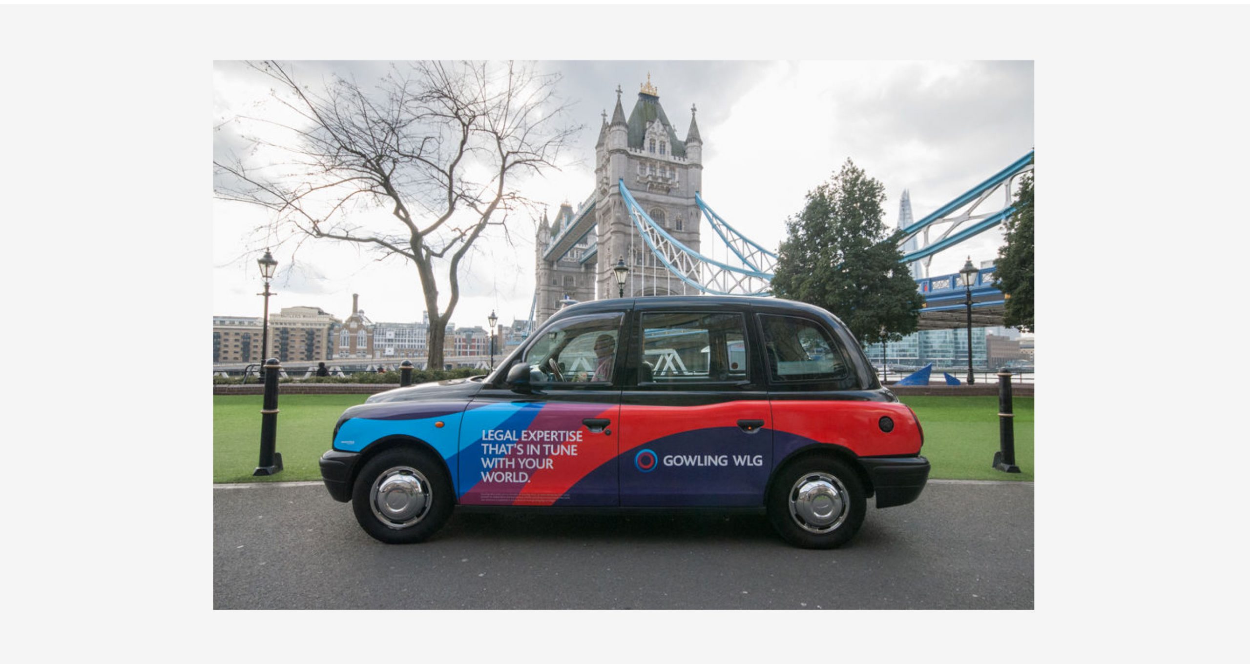 A colourful wrap with the new Gowling WLG logo is displayed on a London taxi cab