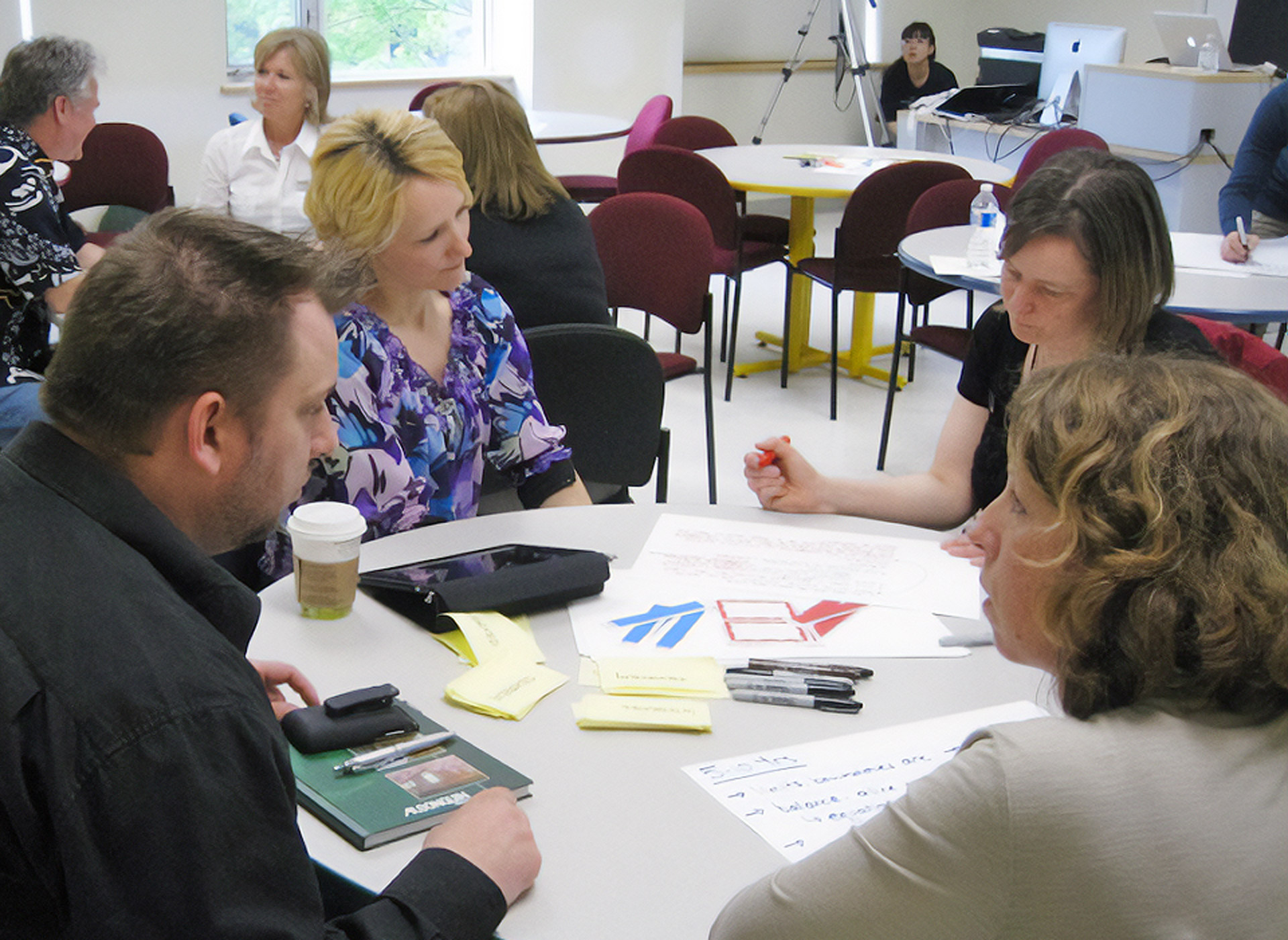 Image of people working together at a round table during a workshop at Algonquin College