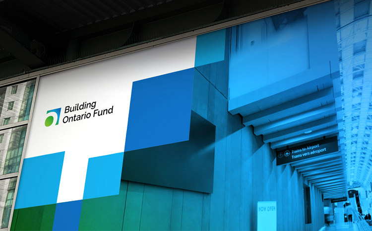 Window decal showing BOF's logo over white and an asymmetric pattern of blue tiles, over a blue and green colourized photograph of a train station