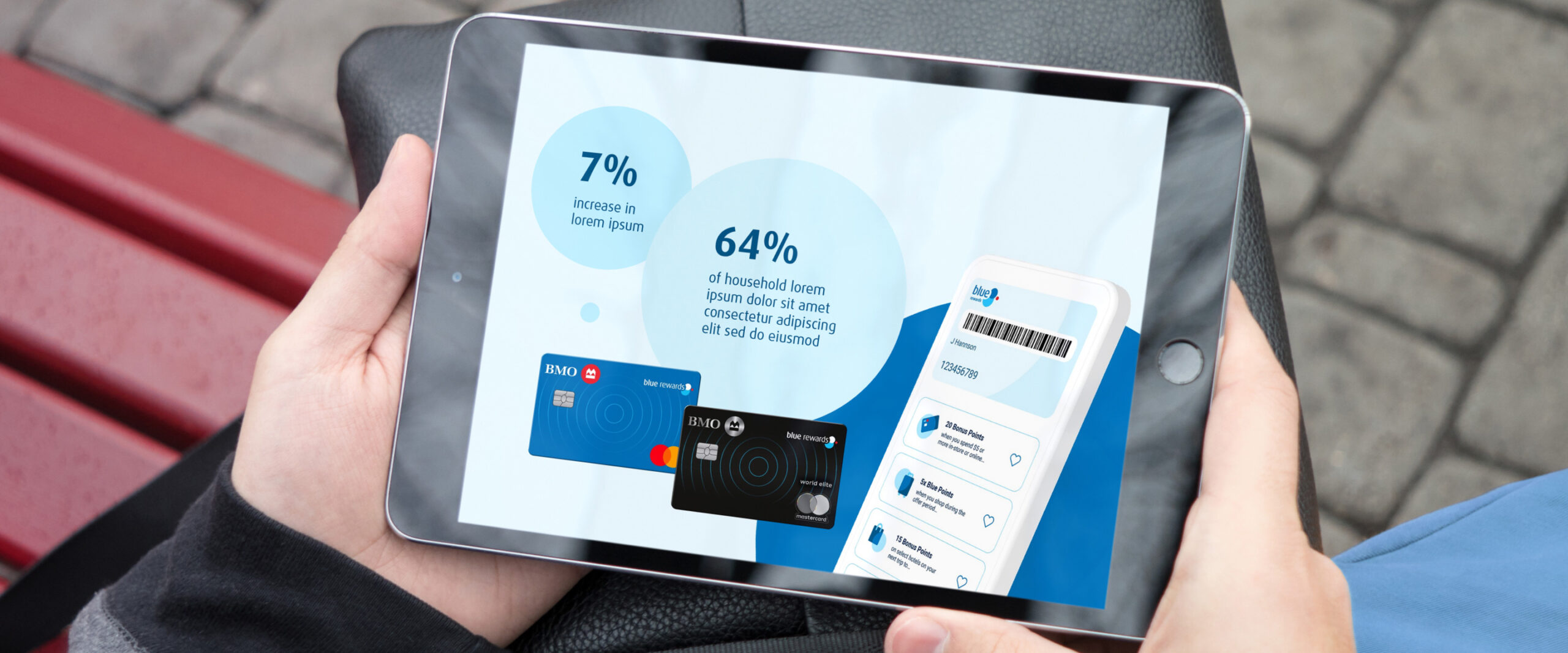 Closeup of a person holding a tablet. A Blue Rewards presentation can be seen on the screen, and it shows text on light blue circles, a mobile phone and two BMO/Blue Rewards credit cards