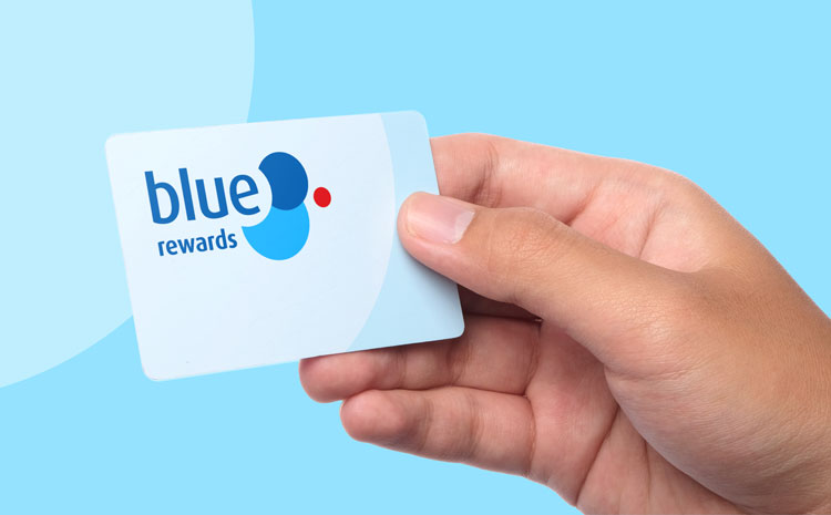 Image of a hand holding a Blue Rewards card, against a light blue background