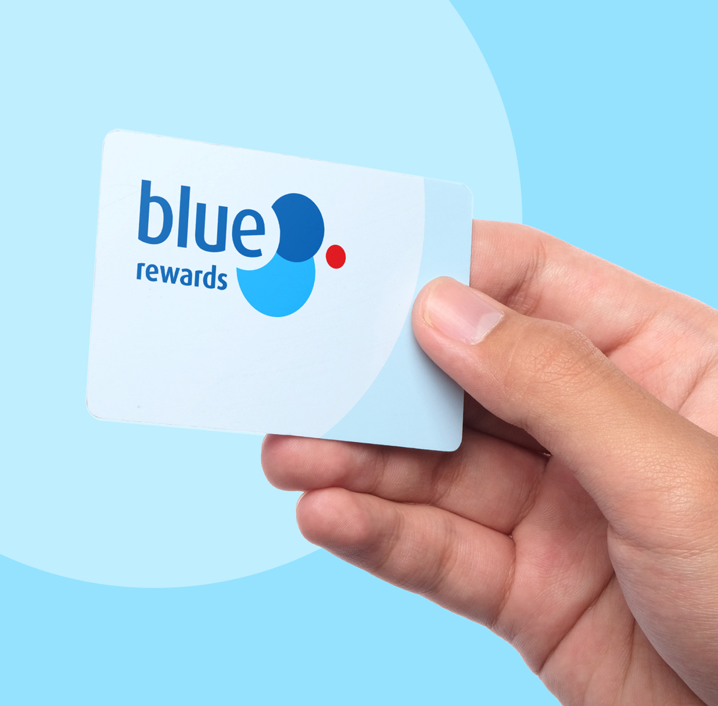 Image of a hand holding a Blue Rewards card, against a light blue background